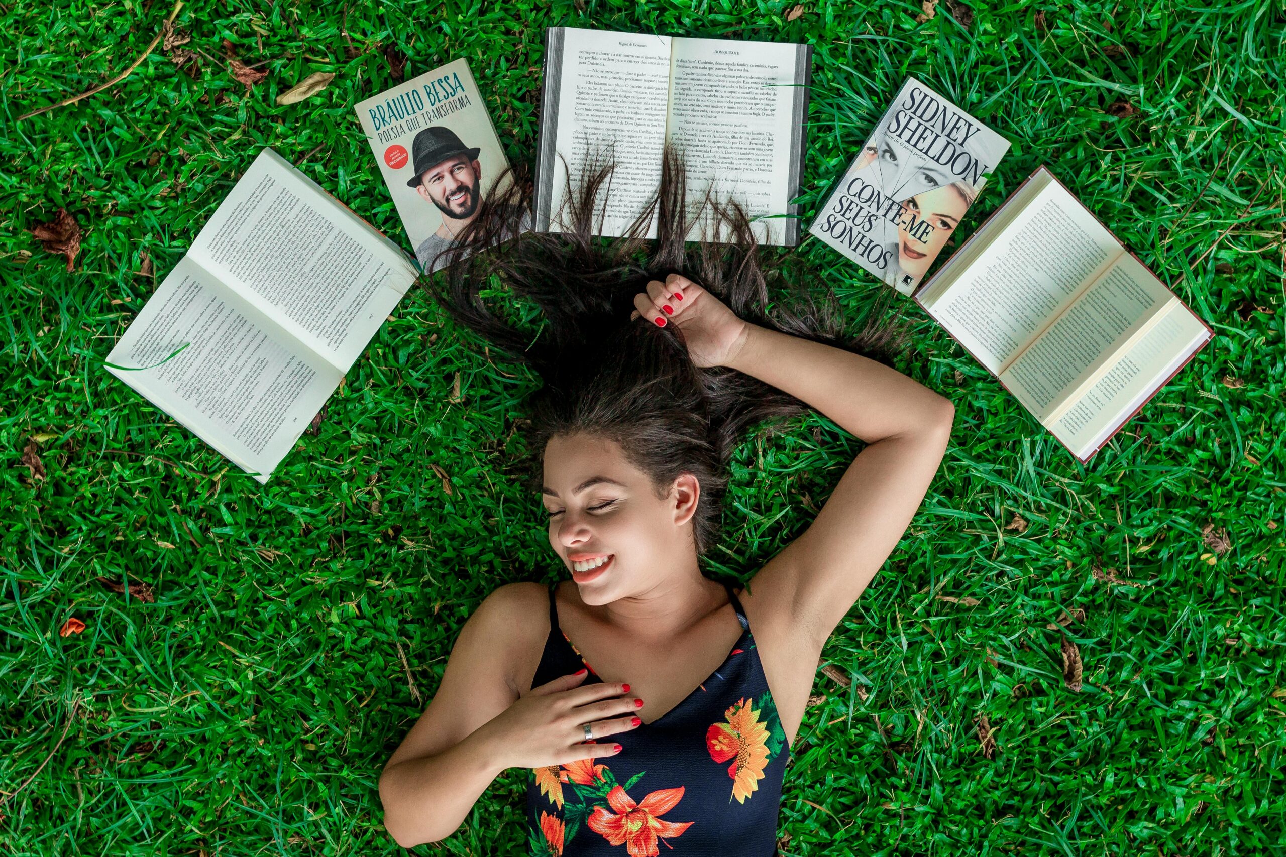 Woman Lying Down on Grass Beside Opened Books