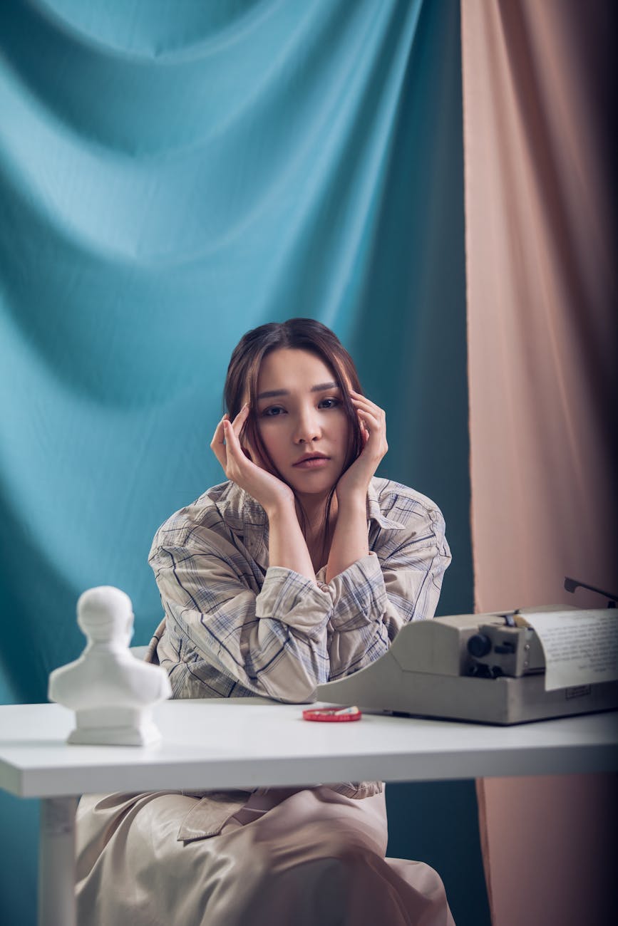 melancholic woman at table with typewriter